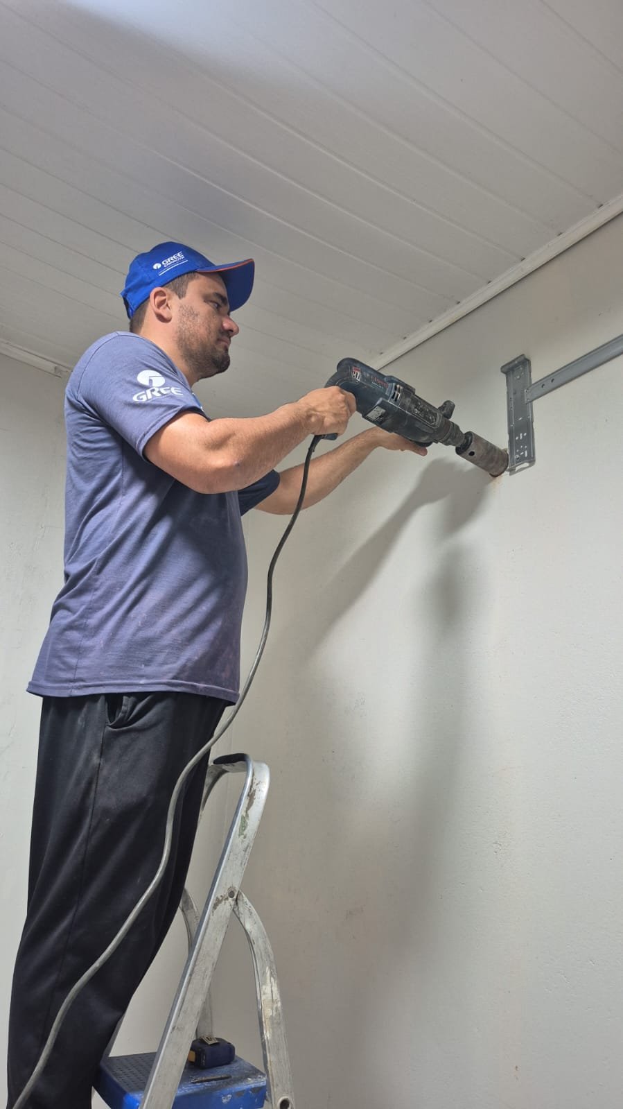 Charles instalando o suporte de um ar-condicionado